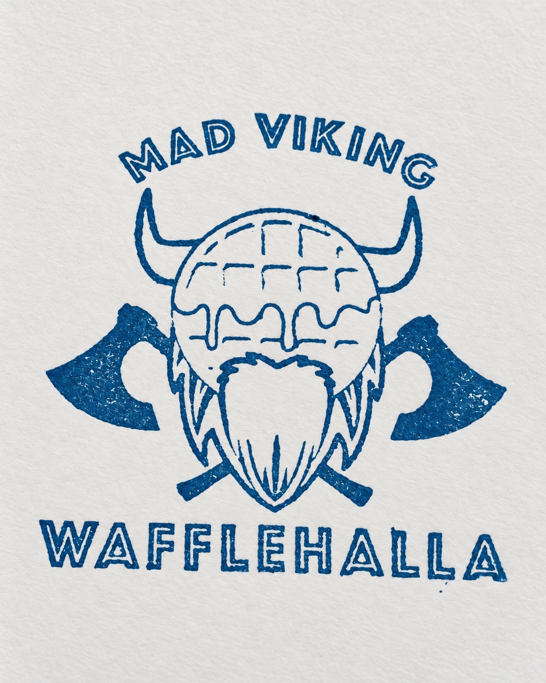 Enhanced close-up of the blue Mad Viking Wafflehalla stamp impression on paper